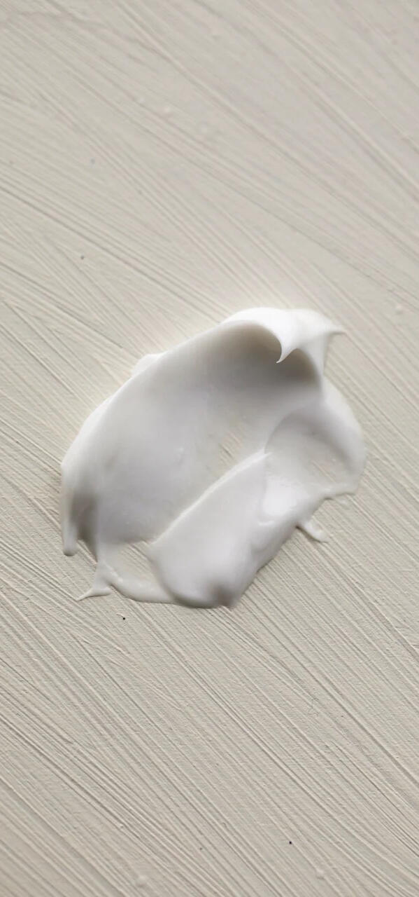 Cream smeared on a cream colored, painted board.